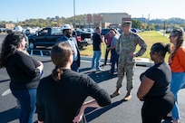 Muhammad-Barakatullah “M-B” Abdussalaam, civil engineer and project manager for the 11th Civil Engineering Squadron, left, talks with U.S. Air Force Col. Ryan A. F. Crowley, commander of Joint Base Anacostia-Bolling and the 11th Wing, and mission partners during a parking lot opening at JBAB, Washington, D.C., Oct. 31, 2024. The civil engineers and contractors surveyed the land, identified unmarked buried cables and adjusted designs to both maintain the communication lines and improve drainage. (U.S. Air Force photo by Staff Sgt. Jordan Powell)