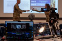 U.S. Air Force Lt. Col. April Clemmensen, 11th Civil Engineer Squadron commander, hands the microphone to U.S. Air Force Col. Ryan A.F. Crowley, commander of Joint Base Anacostia-Bolling and the 11th Wing, during a town hall meeting on Joint Base Anacostia-Bolling, Washington, D.C., Nov. 21, 2024. The event was live-streamed to encourage maximum participation. (U.S. Air Force photo by Staff Sgt. Jordan Powell)