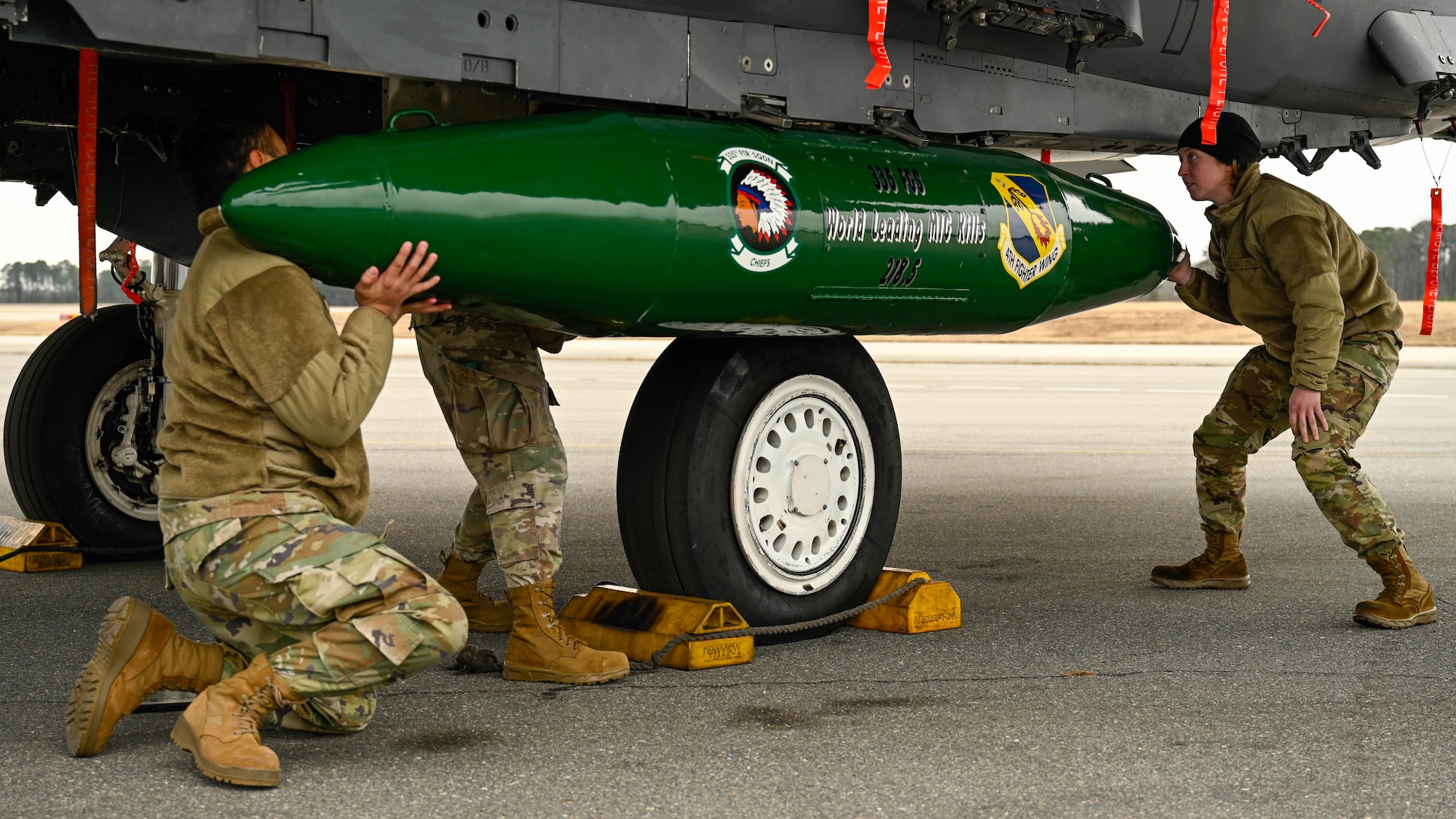 U.S. Airmen assigned to the 335th Fighter Generation Squadron participate in a quarterly load crew competition at Seymour Johnson Air Force Base, North Carolina, Jan. 10, 2025. Each quarter, load crews from each unit compete against each other in a timed competition that tests their dress and appearance, weapons knowledge and speed and accuracy of loading munitions on an F-15E Strike Eagle. (U.S. Air Force photo by Airman 1st Class Rebecca Tierney)