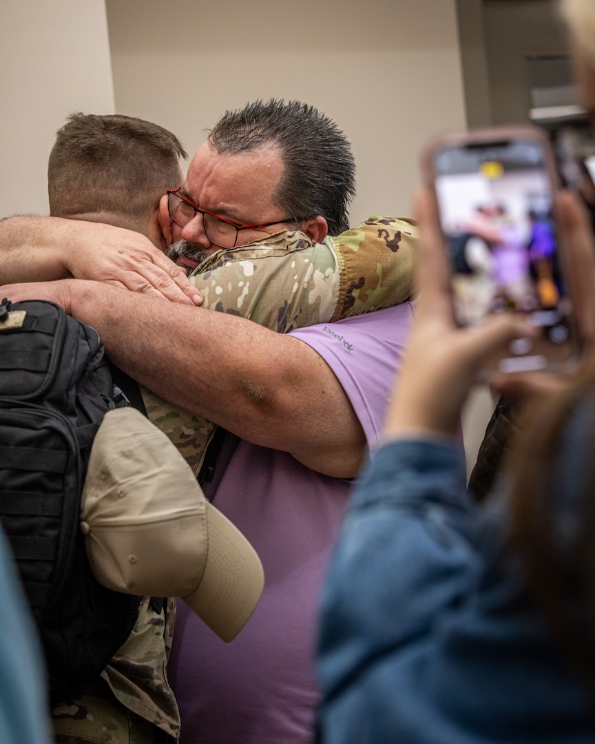 Soldiers and family members embrace during a farewell ceremony for the 1120th Engineer Utilities Detachment at the Muskogee Readiness Center in Muskogee, Oklahoma, Jan. 13, 2025. Approximately 50 Soldiers will deploy overseas in support of United States Africa Command area of responsibility where they will take part in engineering and utilities projects across the Horn of Africa. (Oklahoma National Guard photo by Spc. Danielle Rayon)