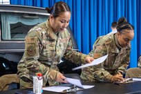 U.S. Air Force Tech. Sgt. Regina Bolante, left, NCO in charge of career development with the 11th Force Support Squadron, and Senior Master Sgt. Rochell Brown, right, flight chief of the 11th FSS Military Personnel Flight, review readiness items for U.S. Air Force and U.S. Space Force Honor Guard guardsmen at Joint Base Anacostia-Bolling, Washington, D.C., Jan. 1, 2025. The 11th FSS ensured 150 personnel were prepared to deploy in support of the State Funeral of former President Jimmy Carter. (U.S. Air Force photo by Staff Sgt. Jordan Powell)