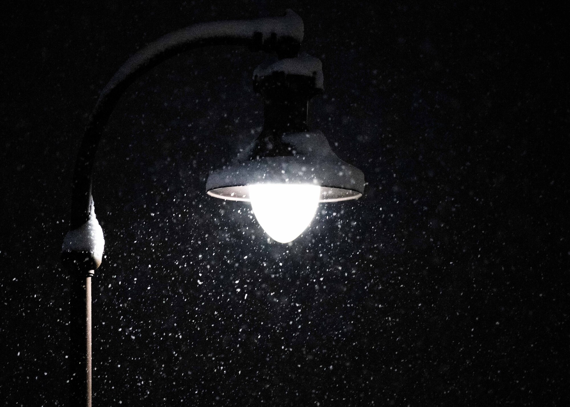 Snow falls past a street lamp at McConnell Air Force Base, Kansas, Jan. 8, 2025. Over the course of five days, approximately nine inches of snowfall covered the surrounding area of Sedgwick County. (U.S. Air Force photo by Airman 1st Class Patrick O'Neill)