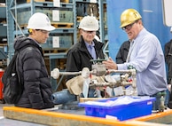 Michael Jeppesen, non-nuclear director, Shop 31, leads a tour of Building 431 for Manuel Hermosilla, deputy commander, Cyber Engineering & Digital Transformation, NAVSEA03, Dec. 2, 2024, at Puget Sound Naval Shipyard & Intermediate Maintenance Facility in Bremerton, Washington. (U.S. Navy photo by Wendy Hallmark)