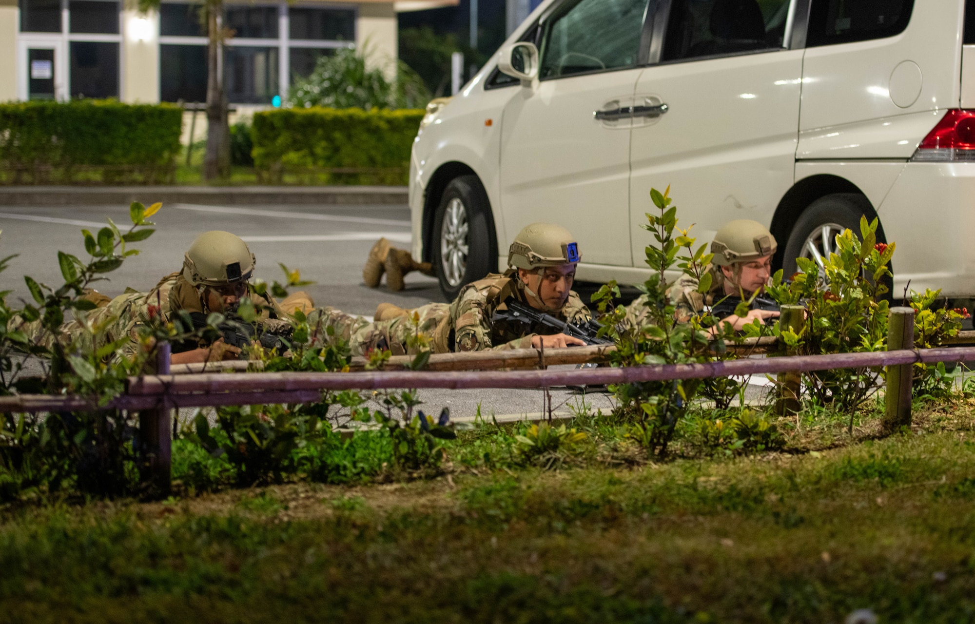 Service members lie on ground.