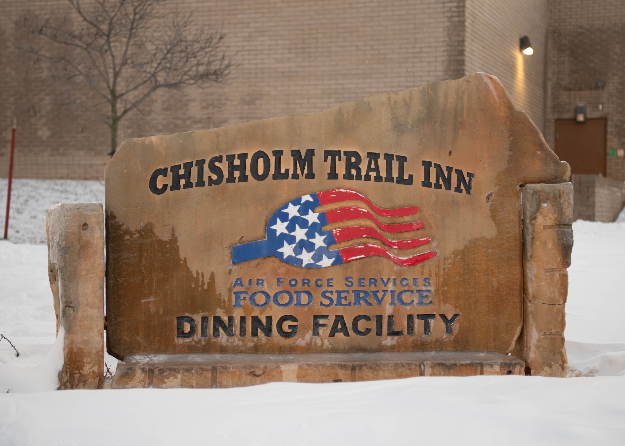Ice covers a sign outside the Chrisholm Trail Inn Dining Facility at McConnell Air Force Base, Kansas, Jan. 8, 2025. Over the course of five days, approximately nine inches of snowfall covered the surrounding area of Sedgwick County. (U.S. Air Force photo by Airman 1st Class Patrick O'Neill)