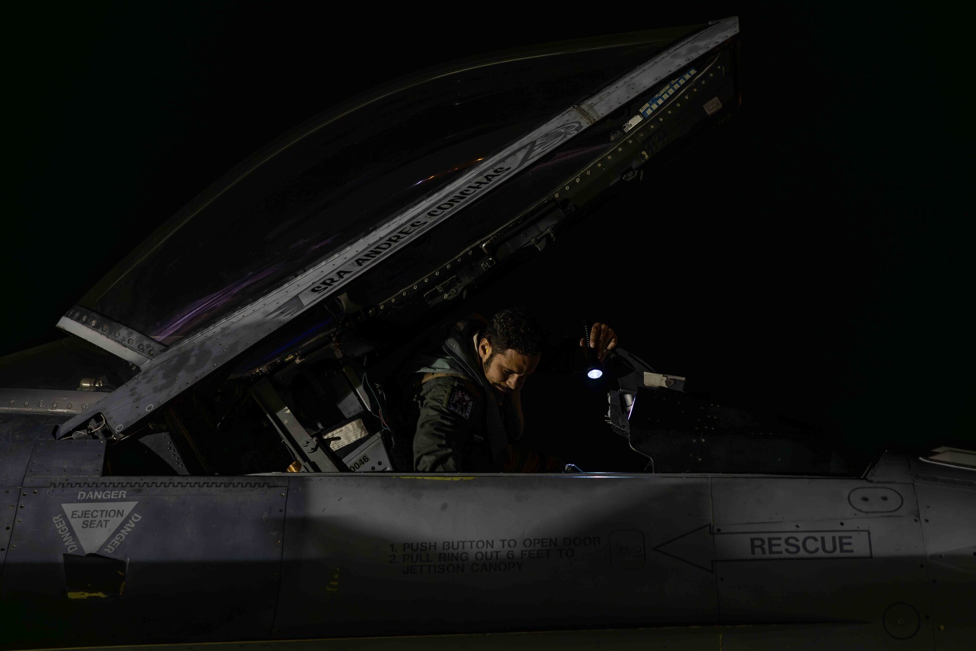 A pilot settles into an aircraft cockpit prior to a flight.
