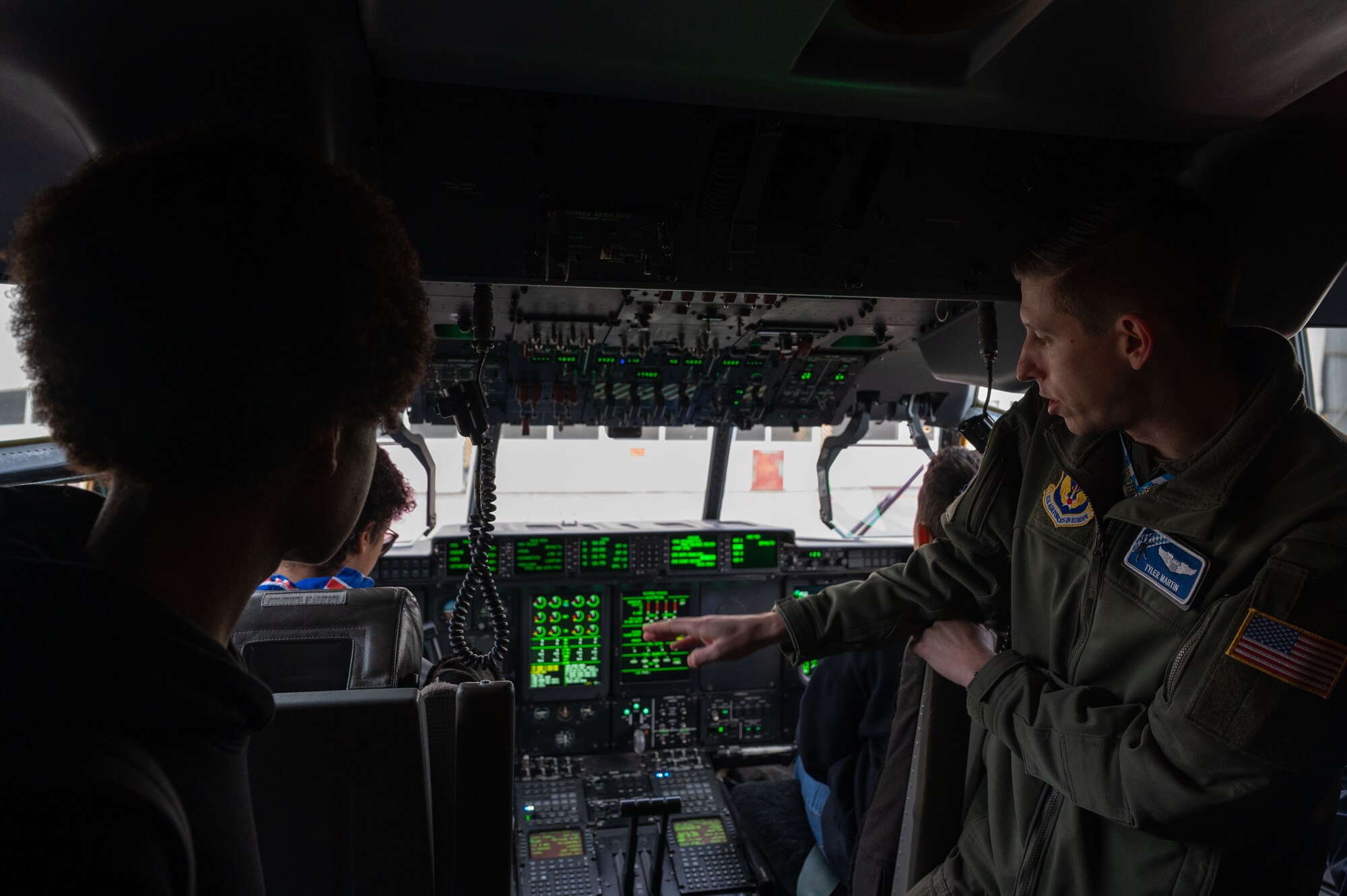 A pilot explains functions of a C-130J to students