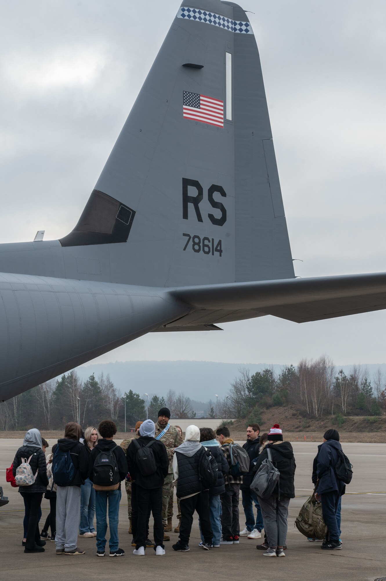 Students stand near a C-130J