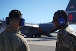 Master Sgt. Alan Franklin, a commander's support Airman with the 146th Airlift Wing, speaks to 1st Lt. Aiden Flores about the Modular Airborne Fire Fighting System mission on the flightline at Channel Islands Air National Guard Station, Port Hueneme, California, Jan. 13, 2025. MAFFS aircraft from the Air National Guard’s 153rd Airlift Wing, Cheyenne, Wyoming, the 152nd Airlift Wing, Reno, Nevada, the 146th Airlift Wing, Port Hueneme, California, and Air Force Reserve Command’s 302 AW, Peterson Air Force Base, Colorado, are working together to combat fires in the Los Angeles area.