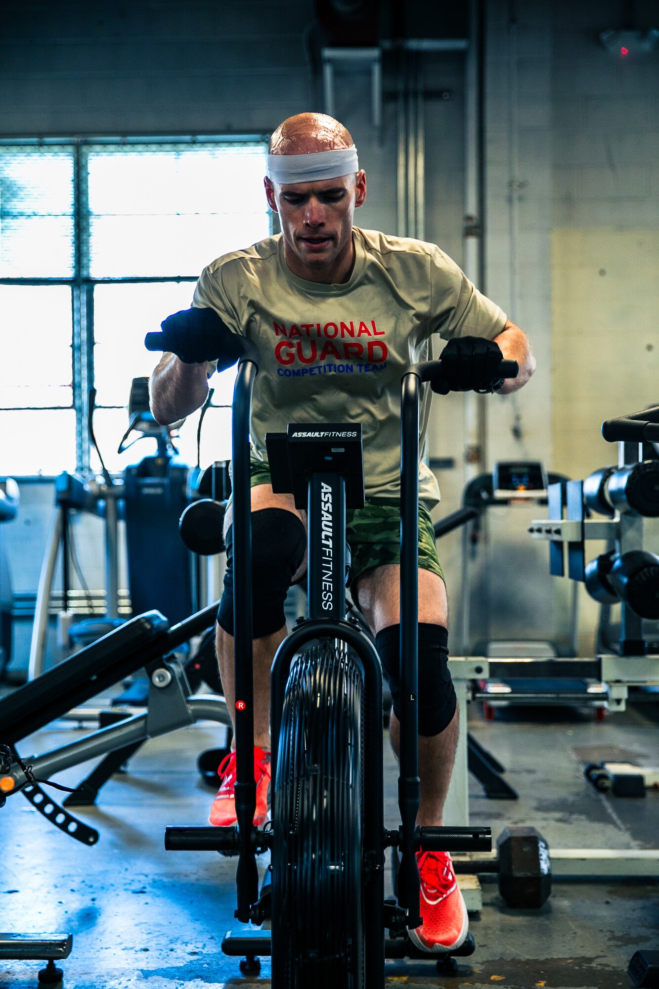 Tim Gribble is shown from the front exercising on a stationary bike in civilian clothes.
