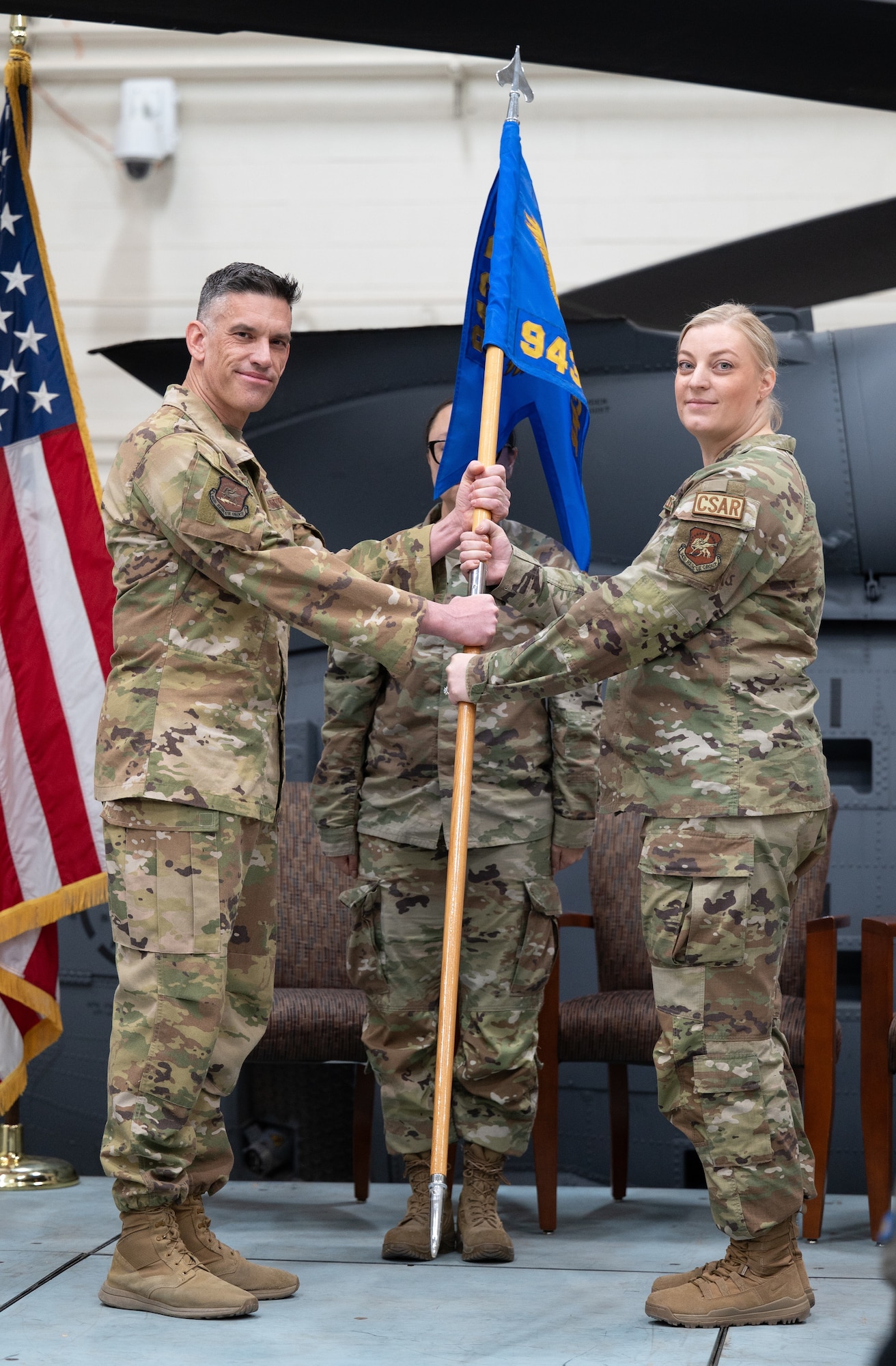 Col. Christopher Escajeda presents the guidon to Maj. Amber Osborne.