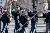 Soldiers from the U.S. Army Old Guard march in formation holding instruments