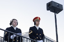Two Soldiers stand together while observing something in the distance