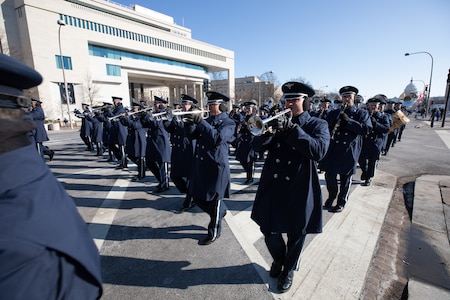 Airmen performing on different instruments while marching