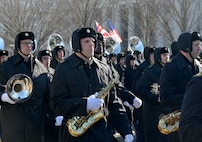 Soldiers hold instruments while marching