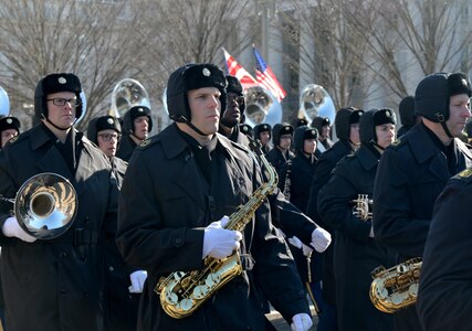 Soldiers hold instruments while marching