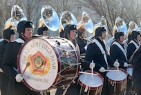 Row of soldiers marching while playing the drums
