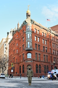 A Marine stands in front of a building