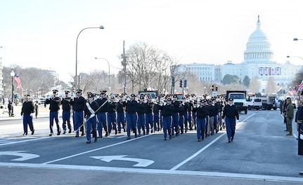 Soldiers march in a parade carrying instruments