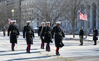 Marines march in parade carrying saber sword