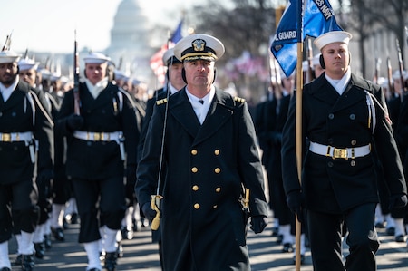 Sailors marching in formation with officer in the front