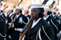 Close up photo of Sailor holding a rifle with a tear falling down his cheek