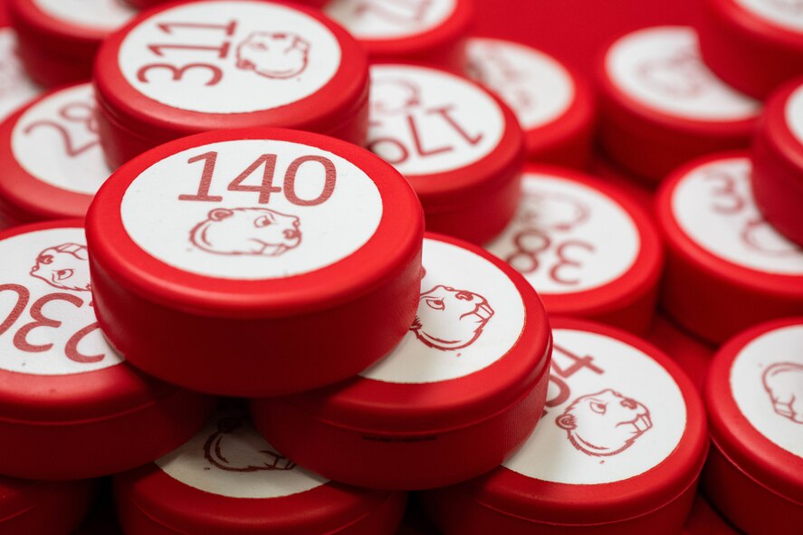 Hockey pucks are displayed during the Minot State University military appreciation hockey game at Maysa Arena, Minot, North Dakota, Jan. 11, 2025. The pucks were used by fans to play a game known as “Chuck-a-Puck” to win prizes during intermissions of the hockey game. (U.S. Air Force photo by Senior Airman Kyle Wilson)