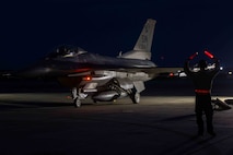 An Airman marshals an aircraft to taxi.