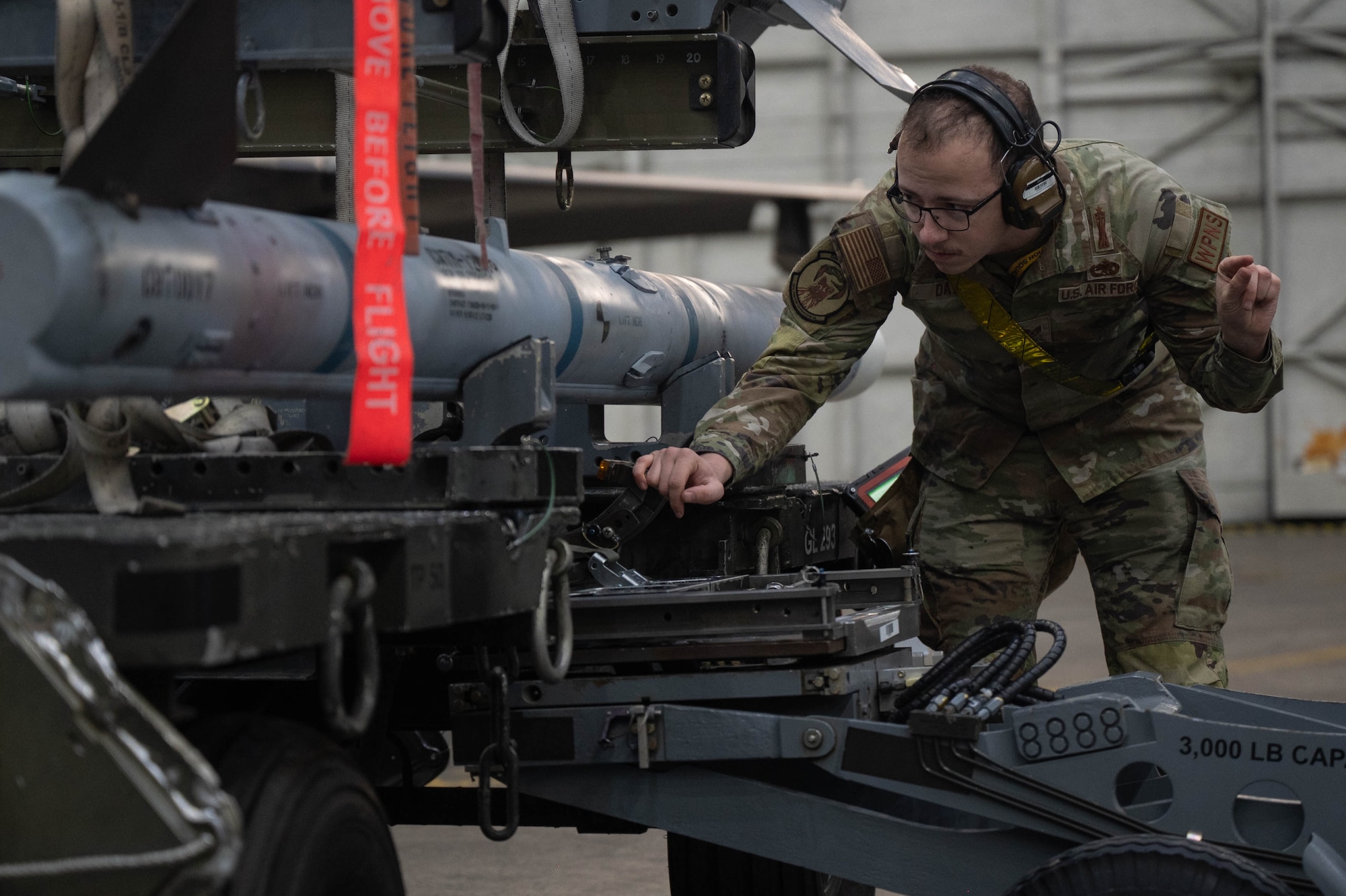 U.S. Air Force Staff Sgt. guides a MJ-1 lift truck arm to an AIM-120 Advanced Medium Range Air-to-Air Missile during the fourth quarter load competition