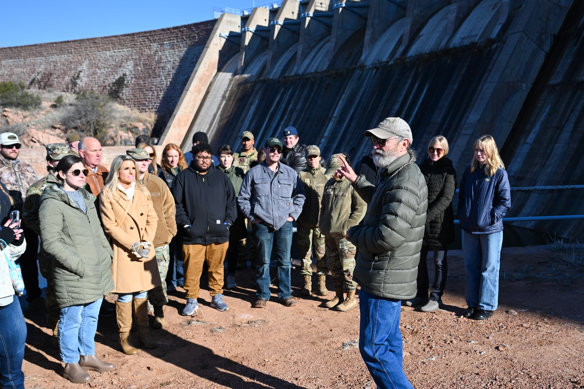 Tom Buchanan, Lugert-Altus Irrigation District manager, briefs Airmen from the 97th Air Mobility Wing and members of the local community about the dam at Lake Altus-Lugert, Oklahoma, Jan. 15, 2025. Buchanan is a local cotton farmer and believes that farmers and military members provide a large scale of safety and security to the nation. (U.S. Air Force Photo by Airman 1st Class Jonah Bliss)