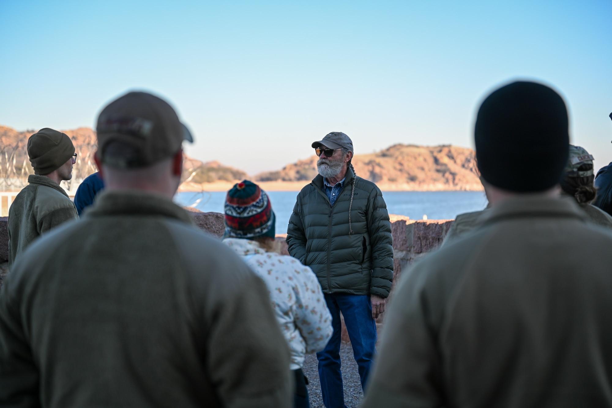 Tom Buchanan, Lugert-Altus Irrigation District manager, briefs Airmen from the 97th Air Mobility Wing and members of the local community about the dam at Lake Altus-Lugert, Oklahoma, Jan. 15, 2025. As the Irrigation District manager, Buchanan oversees the planning, operation, and maintenance of irrigation systems to ensure efficient water delivery to local farmers. (U.S. Air Force Photo by Airman 1st Class Jonah Bliss)