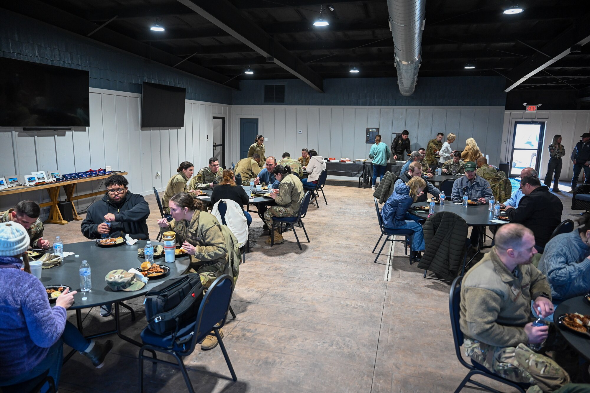 Airmen from the 97th Air Mobility Wing and members of the local community enjoy a lunch provided by the Military Affairs Committee in Altus, Oklahoma, Jan. 15, 2025. During lunch, a local cotton producer, Charlcey Plummer, shared a presentation with the group about how cotton is grown, harvested, and sold. (U.S. Air Force Photo by Airman 1st Class Jonah Bliss)