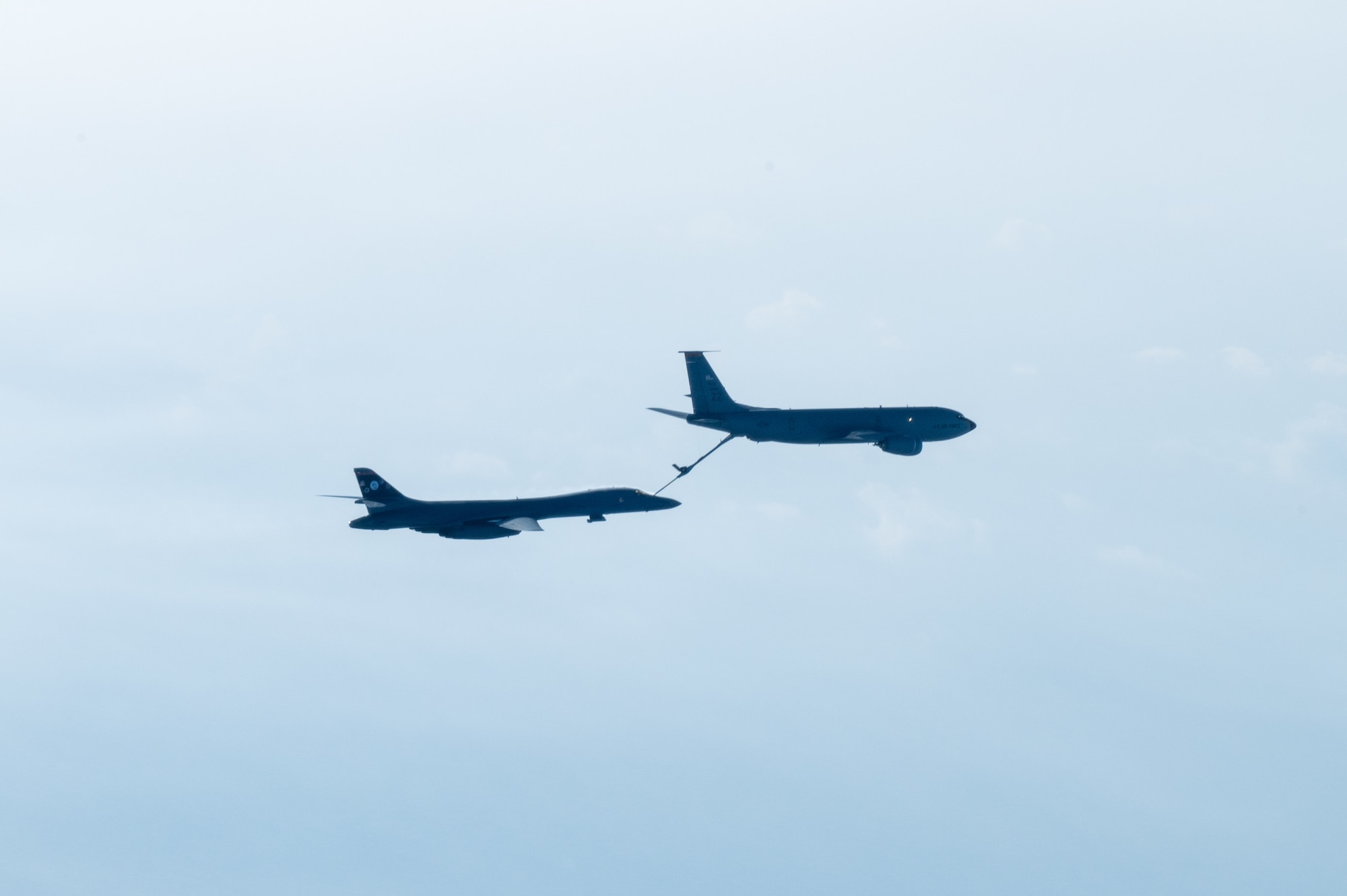 A bomber conducts aerial refueling with a tanker aircraft.