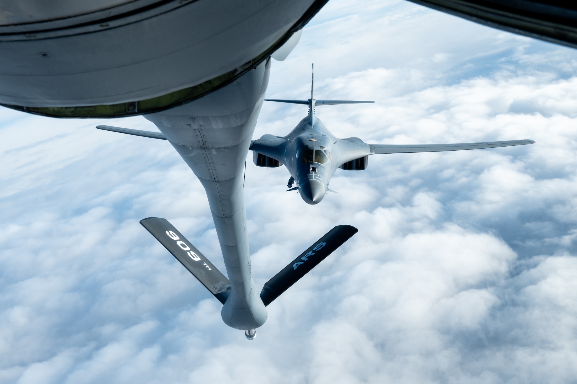 A bomber approaches a boom to conduct aerial refueling.