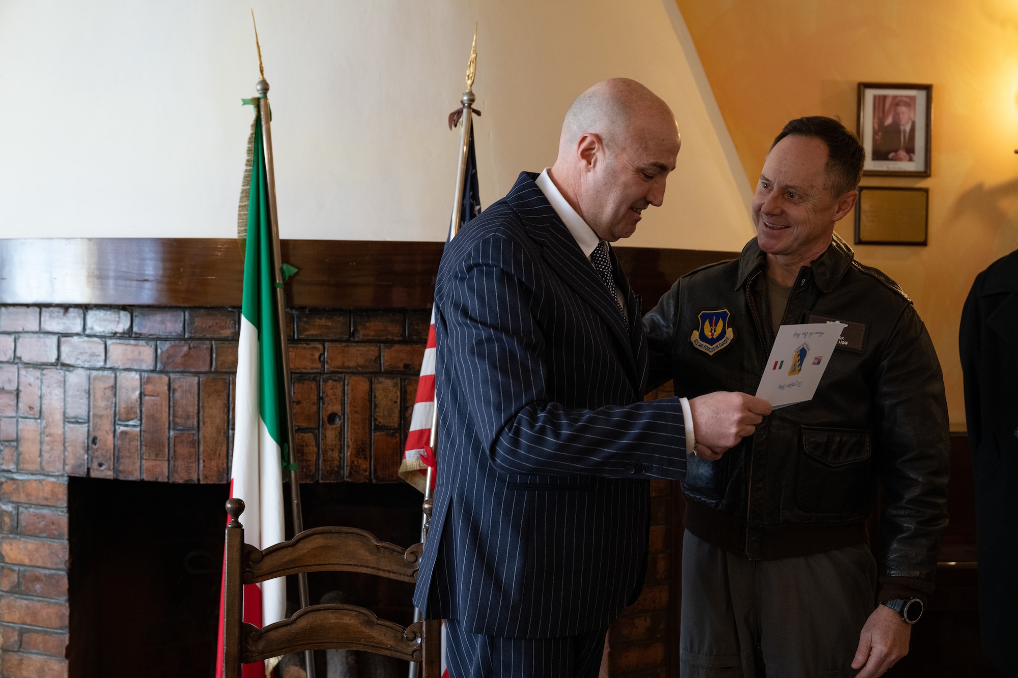 Prefect of Pordenone, Michele Lastella (left), accepts a commander’s coin from U.S. Air Force Brig. Gen. Tad Clark, 31st Fighter Wing commander (right), after his first visit as Prefect to Aviano Air Base, Italy, Jan. 14, 2025.