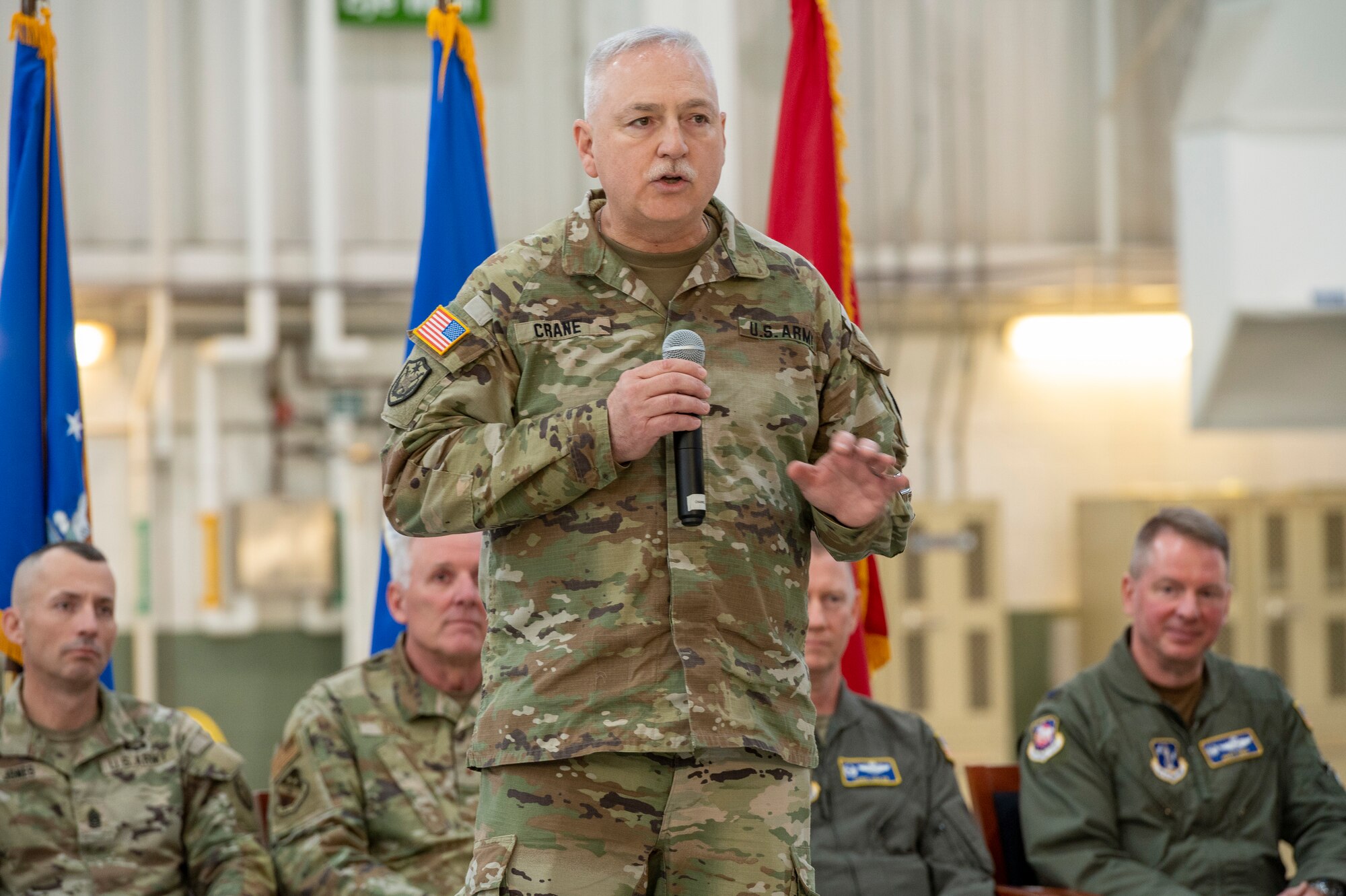 a man in uniform speaks on a stage