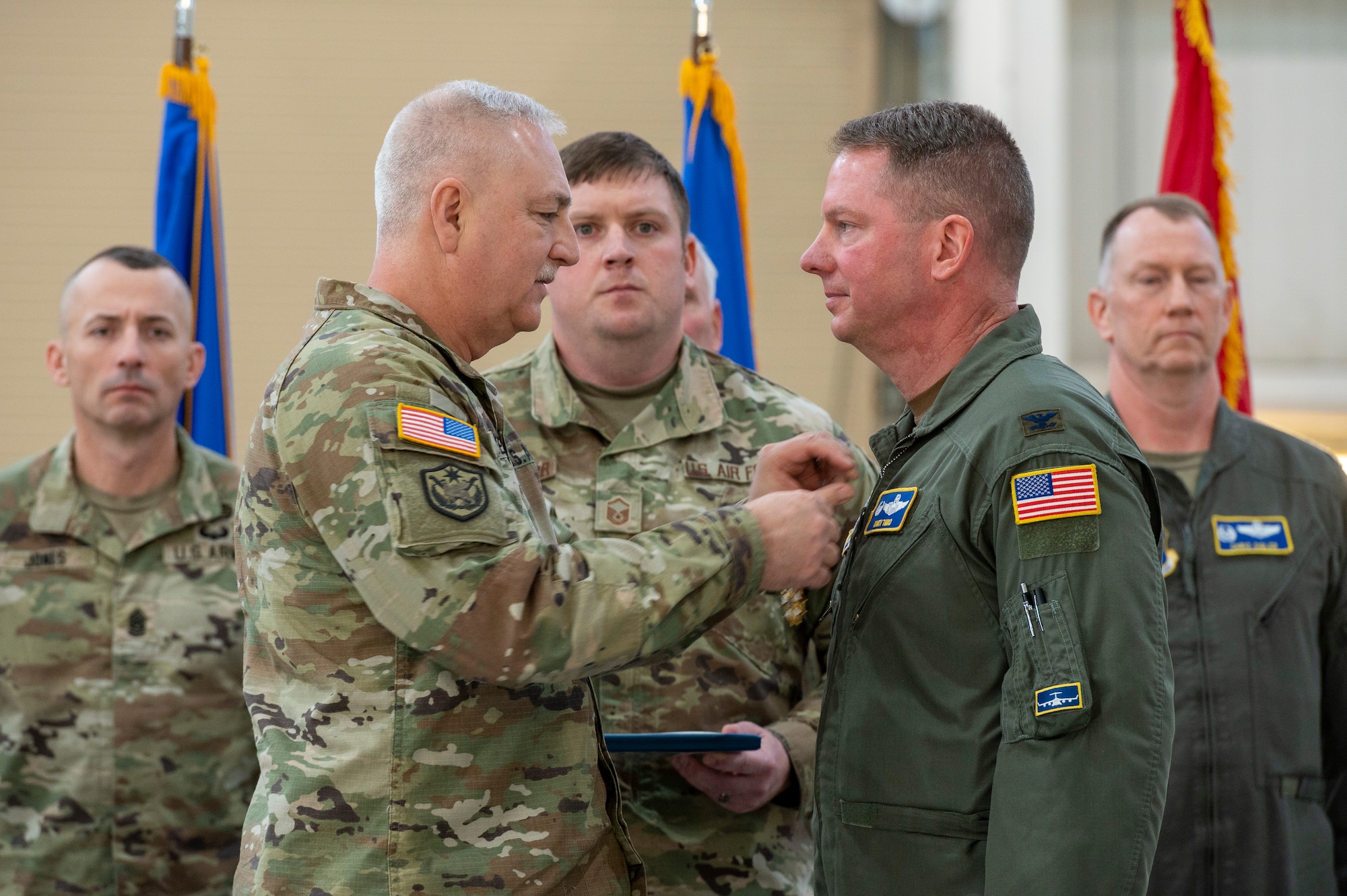 a man pins a medal on the uniform of another man