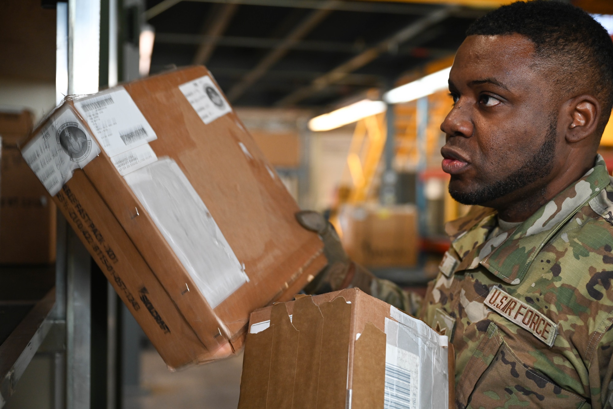 U.S. Air Force Senior Airman Ricardo Wright, 21st Logistics Readiness Squadron central storage journeyman, loads boxes into a military container during the space logistics challenge at Peterson Space Force Base, Colorado, Jan. 15, 2025. The first step of the space logistic challenge was to have members of different skill levels load 111 boxes of cargo into a standard military container to set the base line for the artificial intelligence’s turn later in the day (U.S. Space Force photo by Staff Sgt. Jaime Sanchez)