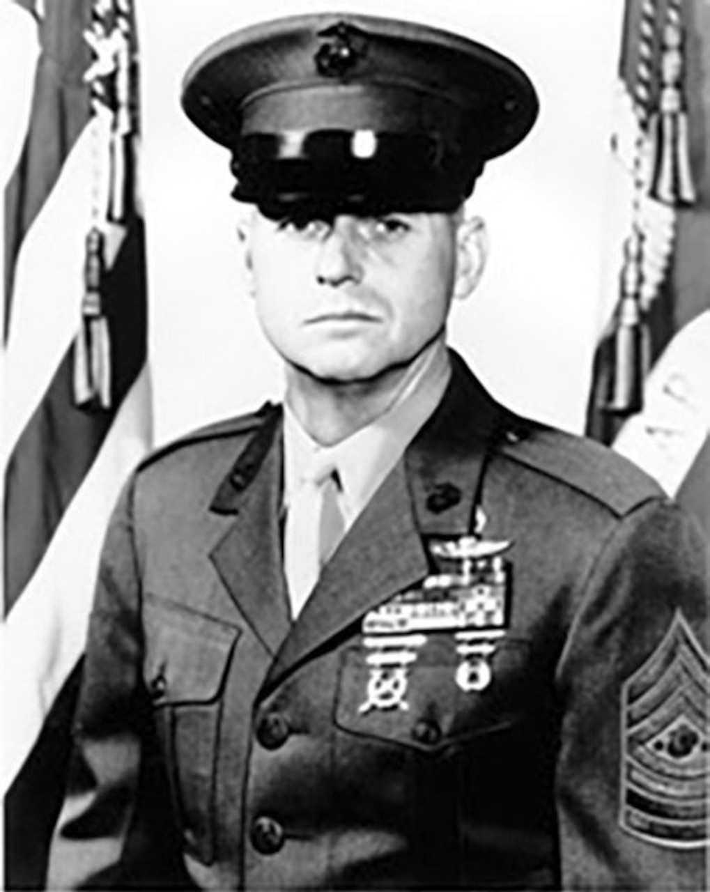 A man in uniform and cap poses for a photo.