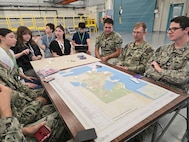 From left to right: High school students Hana Knight, Priscila MacDonald, Ethan Kohlmeyer-Hyman, Maya Knight and Kai Livingston, along with Unmanned Undersea Vehicle Group ONE Sailors Petty Officer Daniel Leno, Petty Officer Christian Lamb, Chief Petty Officer Matthew Howard, Petty Officer Zachary Amsden and Lt. Mark Westman, pictured Aug. 2 during an internship at Naval Undersea Warfare Center Division, Keyport. The students were part of a team of 10 interns who surpassed expectations in their development of an innovative tabletop cybersecurity game called SEACAT. (U.S. Navy photo by Jacob Yakawich/Released)