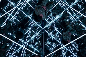 military man sits in the mind gym, surrounded my mirrors and LED lights