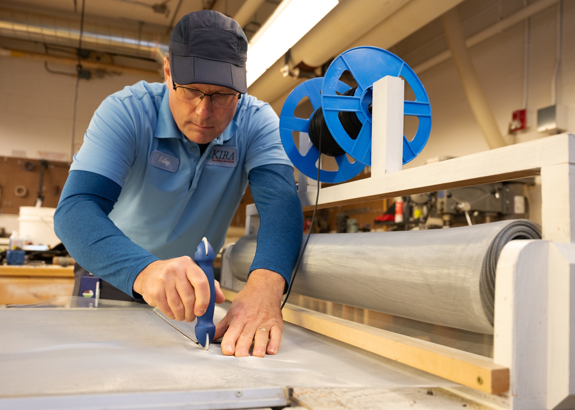 A base maintenance contractor uses a tool to install a wire mesh screen onto a frame at the U.S. Air Force Academy, Colorado on November 13, 2024.