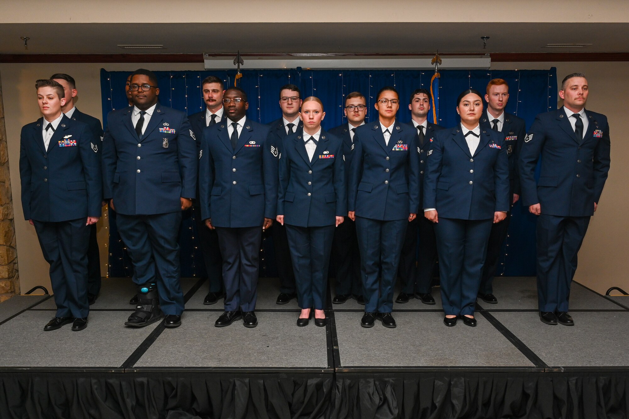 U.S. Air Force Airmen from the 97th Air Mobility Wing stand at attention in Club Altus at Altus Air Force Base, Oklahoma, Jan. 16, 2025. These Airmen were honored for promoting to the rank of staff sergeant at a noncommissioned officer induction ceremony. (U.S. Air Force Photo by Airman 1st Class Jonah Bliss)
