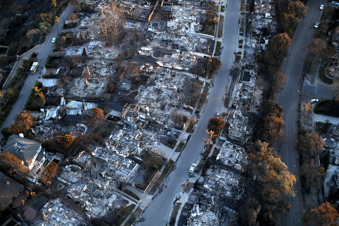 An aerial view of a neighborhood street with numerous demolished houses.
