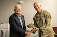 Retired U.S. Army Maj. Gen. Stephen Collins, left, is presented with a special operations forces challenge coin and hat by U.S. Army Col. Jess Marasalis, the program executive officer for Special Operations Forces, at his retirement ceremony at Bluegrass Station in Lexington, Kentucky on Dec. 10, 2025. Collins is retiring as the director of Bluegrass Station after serving for 16 years as the longest serving director. (U.S. Army National Guard photo by Andy Dickson)