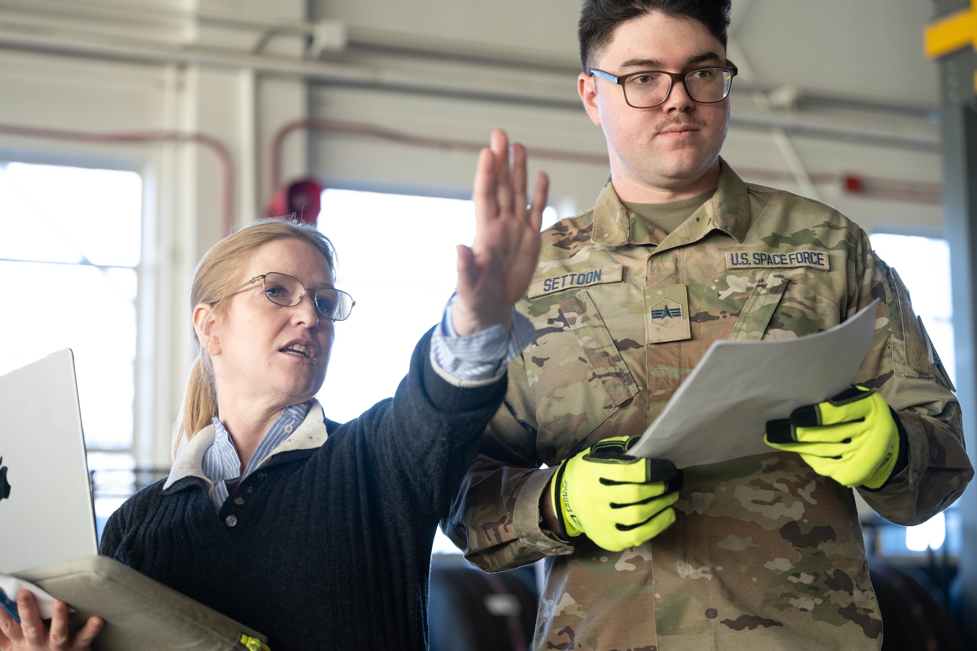 Elenor Mitch, PackOPS AI chief executive officer and U.S. Space Force Spc. 4 Blake Settoon, 62nd Cyberspace Squadron defensive cyber operator, discuss the optimized plan provided by the artificial intelligence during the space logistics challenge at Peterson Space Force Base, Colorado, Jan. 15, 2024. The final test showcased the ability for the AI tool to develop loading instruction for personnel, enabling human-AI collaboration. (U.S. Space Force photo by Staff Sgt. Jaime Sanchez)