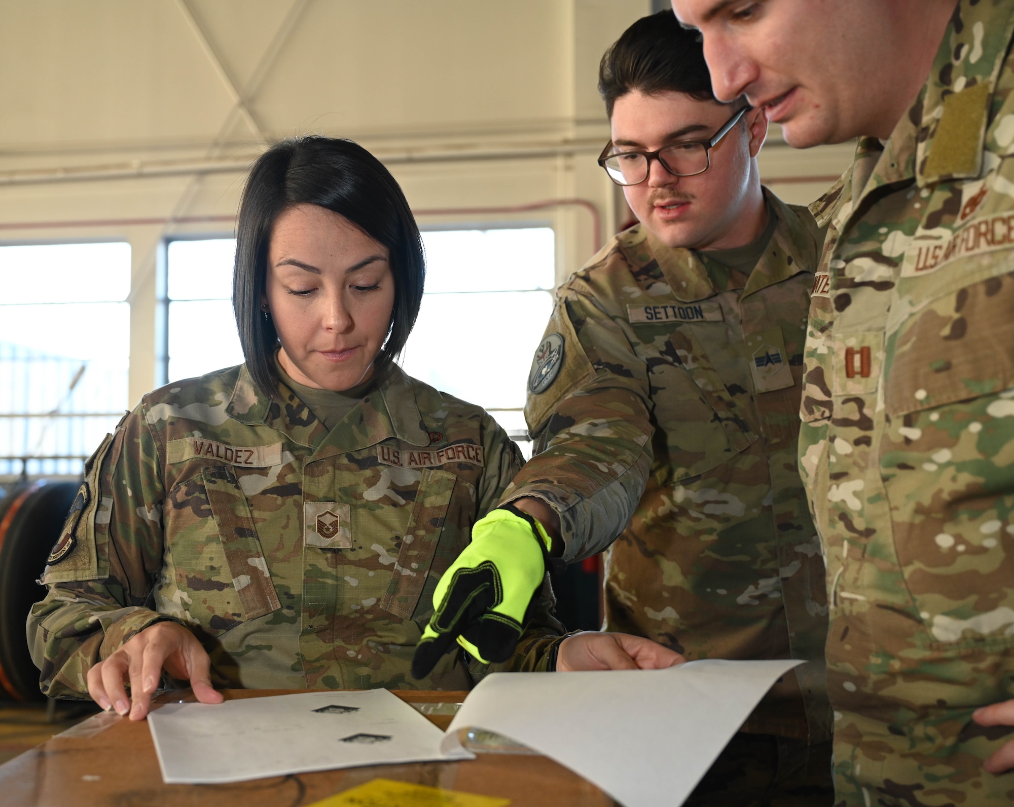 U.S. Air Force Master Sgt. Audrey Valdez, 21st Logistics Readiness Squadron materiel management superintendent, and U.S. Space Force Spc. 4 Blake Settoon, 62nd Cyberspace Squadron defensive cyber operator, discuss the artificial intelligence optimized loading plan during the space logistics challenge at Peterson Space Force Base, Colorado, Jan. 15, 2025. During the final test, members had an opportunity to use optimized loading instructions provided by the artificial intelligence tool. (U.S. Space Force photo by Staff Sgt. Jaime Sanchez)
