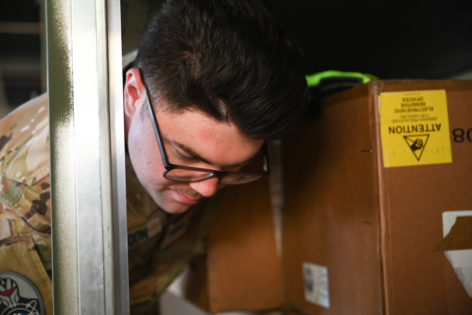 U.S. Space Force Spc. 4 Blake Settoon, 62nd Cyberspace Squadron defensive cyber operator, rearranges boxes in the military container during the space logistics challenge at Peterson Space Force Base, Colorado, Jan. 15, 2025. This day-long challenge was the first time an artificial intelligence tool was used in loading a military container, paving the way for more rapid planning and loading in future. (U.S. Space Force photo by Staff Sgt. Jaime Sanchez)