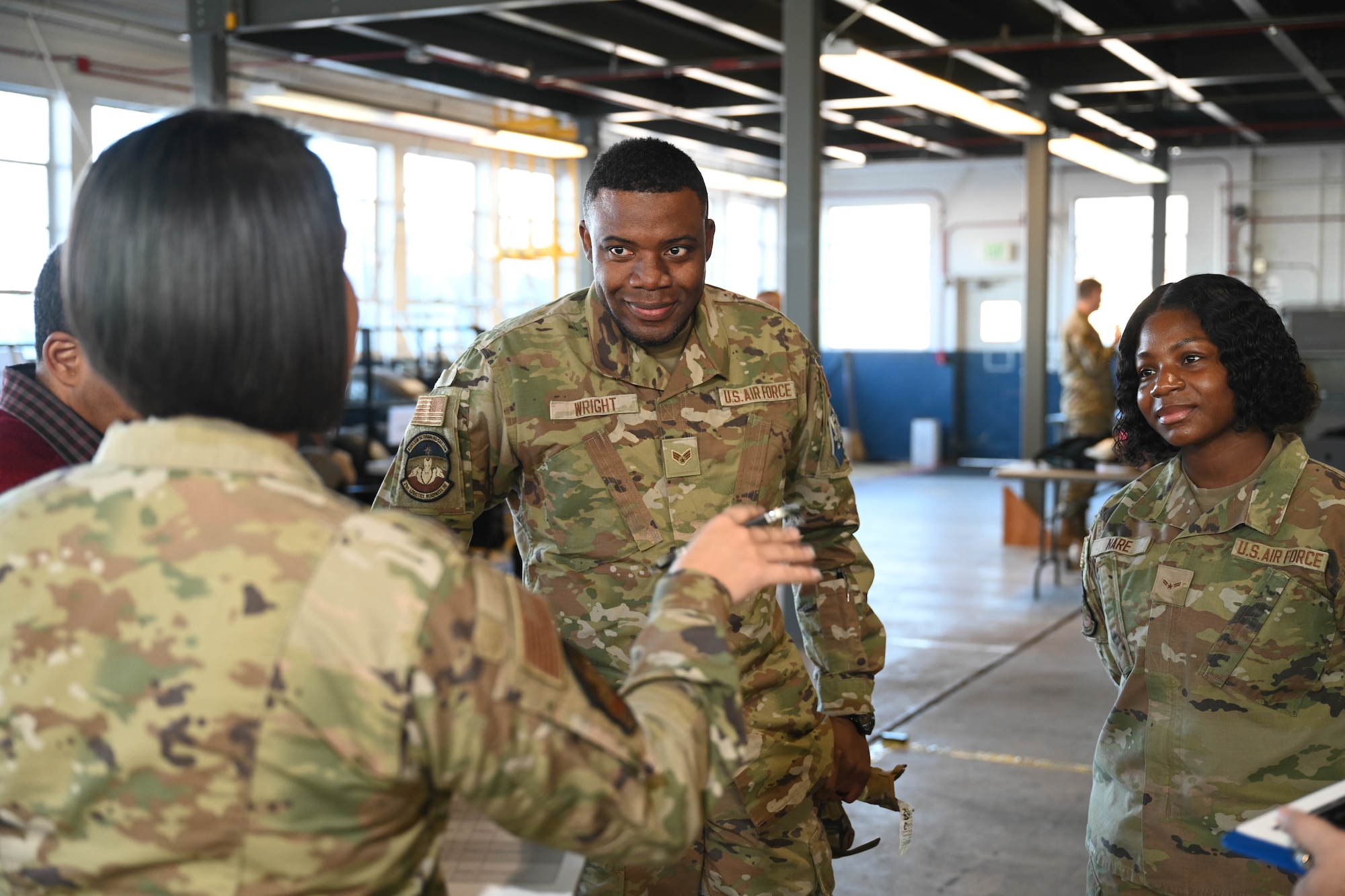 U.S. Air Force Senior Airman Ricardo Wright, 21st Logistics Readiness Squadron central storage journeyman, and USAF Airman 1st Class Mya Nare, 21st LRS air transportation journeyman, listen to their debrief during the space logistics challenge at Peterson Space Force Base, Colorado, Jan. 15, 2025. Using their knowledge and skills, both Wright and Nare finished the test and were debriefed on their performance. Later, they used instructions provided by artificial intelligence to load the cargo container. (U.S. Space Force photo by Staff Sgt. Jaime Sanchez)