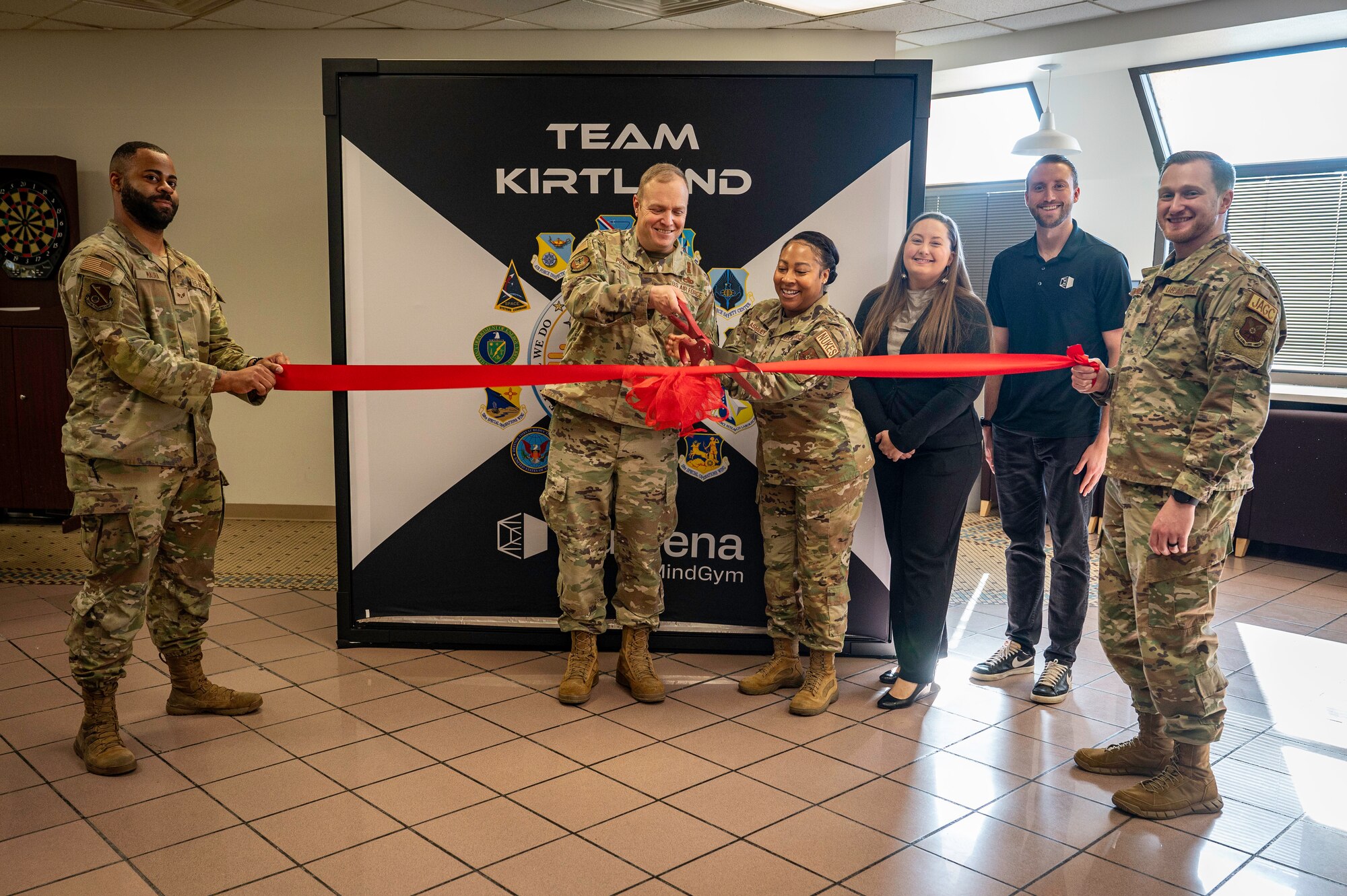 Military members cut red ribbon indoors